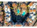 Overhead view of resort-style community pool and spa surrounded by red tile roofs and landscaping at 30 Strada Di Villaggio # 227, Henderson, NV 89011