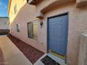 The home's entry has a steel-door, red rock landscaping, and a small, decorative, patterned entrance mat at 37 Belle Soleil Ave, Las Vegas, NV 89123