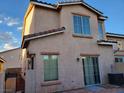 Backyard view of the home with large window, sliding glass door and small grassy area and courtyard at 37 Belle Soleil Ave, Las Vegas, NV 89123