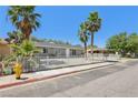 Full front view of a one story home with desert landscaping and mature trees at 4825 Stillwater Ave, Las Vegas, NV 89110
