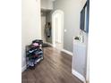 Hallway with modern wood-look floors, neutral paint, and an arched doorway at 4848 Cutting Diamond Ct, North Las Vegas, NV 89081