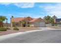 Single-story home with a tile roof, desert landscaping, and an attached two-car garage at 5033 Austrian Dr, Las Vegas, NV 89130
