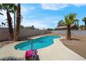 Backyard swimming pool surrounded by mature palm trees and desert landscaping at 5033 Austrian Dr, Las Vegas, NV 89130