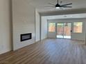 Bright living room featuring wood floors, a modern fireplace, and sliding glass doors to the yard at 5600 Nimes Ave, Las Vegas, NV 89141