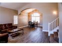 Open concept living room featuring wood floors, vaulted ceilings, and a staircase leading upstairs at 6293 Pavestone Ln, Las Vegas, NV 89142