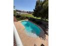 Inviting backyard pool with a spacious concrete deck and views of the neighborhood park at 6293 Pavestone Ln, Las Vegas, NV 89142