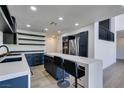 Modern kitchen features stainless steel appliances, sleek cabinetry, quartz countertops and island seating at 7132 Mission Hills Dr, Las Vegas, NV 89113