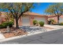 Exterior view of the home featuring a tile roof, two-car garage, desert landscaping, and a private entry gate at 731 Appletree Ln, Mesquite, NV 89027