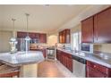Modern kitchen with stainless steel appliances, granite countertops, and dark wooden cabinets at 8316 Accolade St, Las Vegas, NV 89139