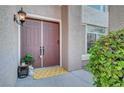 Inviting front entryway featuring double doors, stylish light fixture, and decorative potted plant at 8812 Glenistar Gate Ave, Las Vegas, NV 89143