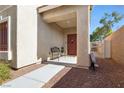 Inviting front porch area with a small seating bench and a decorative front door at 9004 Harbor Wind Ave, Las Vegas, NV 89178