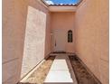 Enclosed front entrance with painted stucco walls and covered entry way to front door at 918 Ambusher St, Henderson, NV 89014