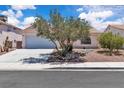 Charming home featuring desert landscaping, mature trees and a two car garage at 918 Ambusher St, Henderson, NV 89014