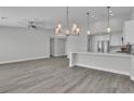 Open-concept living space boasts modern lighting, ceiling fan, and beautiful light gray flooring at 918 Ambusher St, Henderson, NV 89014