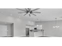 Bright and open living space showcases a ceiling fan, pendant lights, and a modern kitchen at 918 Ambusher St, Henderson, NV 89014