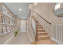 Inviting entryway with tile flooring, a staircase, and decorative wall shelves adding a touch of charm at 10623 Kearney Mountain Ave, Las Vegas, NV 89166