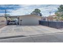 Gated driveway and carport with desert landscaping, horizontal siding, and black metal fence at 224 Catalini St, Las Vegas, NV 89107