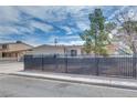 Home exterior with desert landscaping, horizontal siding, and black metal fence at 224 Catalini St, Las Vegas, NV 89107