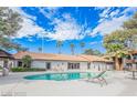 Inviting community pool, surrounded by lounge chairs and lush landscaping with palm trees at 2606 S Durango Dr # 142, Las Vegas, NV 89117