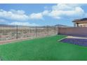 Fenced backyard with artificial turf and low-maintenance desert landscaping; mountain views at 2728 Tricase St, Henderson, NV 89044