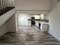 Open concept living area with wood-look flooring leading to the kitchen and staircase at 3681 Melonies Dr # 29, Las Vegas, NV 89103