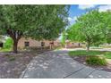 Beautiful home with a circular driveway, mature shade trees, and lush landscaped yard at 3753 Meadowcrest Dr, Las Vegas, NV 89121