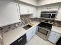 Modern kitchen with white cabinetry, stainless steel appliances, and mosaic backsplash at 435 Mesa Blvd # 202, Mesquite, NV 89027