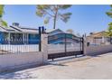 Landscaped home exterior featuring secure, ornate fencing and a large, gated driveway at 4490 W Warm Springs Rd, Las Vegas, NV 89118