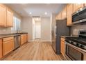 Bright kitchen features stainless steel appliances, wood cabinets and modern recessed lighting at 455 Westminster Hall Ave # 101, North Las Vegas, NV 89032