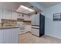 Well-lit kitchen with white cabinets, modern appliances, and tile flooring at 4742 Obannon Dr # A, Las Vegas, NV 89102