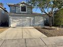 Charming two-story home features a two-car garage, desert landscaping and mature shade tree in front yard at 6063 Peach Orchard Rd, Las Vegas, NV 89142