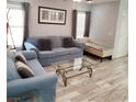 Cozy living room with plush seating, neutral tones, and wood-look tile flooring at 6283 Lapilli Ave, Las Vegas, NV 89139