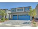 Charming two-story home with a spacious two car garage, landscaped front yard, and blue painted garage doors at 629 Soaring Wings Ave, Las Vegas, NV 89183
