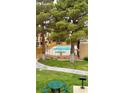 Apartment community swimming pool and grilling area bordered by tall trees and landscaping at 8101 W Flamingo Rd # 2110, Las Vegas, NV 89147
