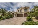 Charming two-story home displaying a tile roof, three-car garage, and lush palm trees at 11241 Pentland Downs St, Las Vegas, NV 89141