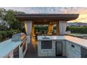Outdoor kitchen featuring a grill, sink, refrigerator, and counter space, ideal for outdoor cooking and gatherings at 15 Golden Sunray Ln, Las Vegas, NV 89135
