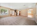 Open-concept living room with plush carpeting, neutral paint, and abundant natural light at 1826 Monte Alban Dr, North Las Vegas, NV 89031