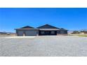 Well-maintained single-story home with a two-car garage and desert landscaping at 1830 Justine Ct, Pahrump, NV 89048