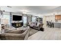 Bright, open living room with plush seating, light wood floors, and large TV, creating a comfortable and inviting space at 2370 Via Firenze, Henderson, NV 89044