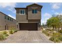 Stylish two-story home showcasing a brick driveway, a two-car garage, and desert-friendly landscaping at 2732 Roman Palm Rd, North Las Vegas, NV 89086
