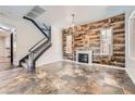 Open-concept living room featuring a decorative fireplace, wood accent wall, and staircase to the second level at 3198 Stella Cilento Ave, Henderson, NV 89044