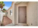 Close up of the front door and walkway with low maintenance landscaping and neutral paint scheme at 406 River Glider Ave, North Las Vegas, NV 89084