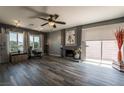 Spacious living room with modern ceiling fan, cozy fireplace, and sliding glass door leading to the patio at 4129 Ridgewood Ave, Las Vegas, NV 89120