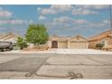 Charming single-story home boasts a tile roof, desert landscaping, and a spacious three-car garage at 47 Desert Sunflower Cir, Henderson, NV 89002
