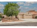 Charming single-story home boasts a tile roof, desert landscaping, and a spacious three-car garage at 47 Desert Sunflower Cir, Henderson, NV 89002