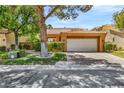 Beautiful home with a lovely front yard, mature trees, and a two-car garage on a sunny day at 5123 Southern Hills Ln, Las Vegas, NV 89113