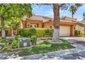 A lovely home featuring mature trees, lush lawn, and a charming tile roof at 5123 Southern Hills Ln, Las Vegas, NV 89113