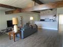 Bright and airy living room featuring wood beams, modern flooring and open kitchen access at 6409 Burgundy Way, Las Vegas, NV 89107