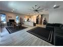 Spacious living room and kitchen features tile flooring, stainless steel appliances, and a large ceiling fan at 6450 Cinnamon Hazlenut St, North Las Vegas, NV 89084