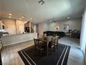 Open floor plan showcasing living room and kitchen with tile flooring, dark area rugs, and stainless steel appliances at 6450 Cinnamon Hazlenut St, North Las Vegas, NV 89084